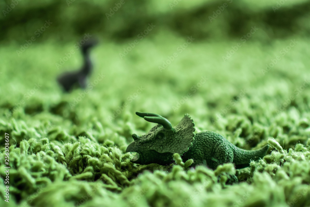 Toy dinosaurs in high grass miniature wild life Toy dinosaurs in high grass miniature wild life