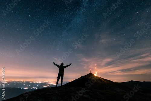 Italy, Monte Nerone, silhouette of a man looking at night sky with stars and milky way