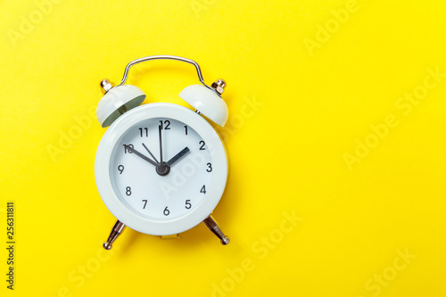 Ringing twin bell vintage classic alarm clock Isolated on yellow colourful trendy modern background. Rest hours time of life good morning night wake up awake concept. Flat lay top view copy space