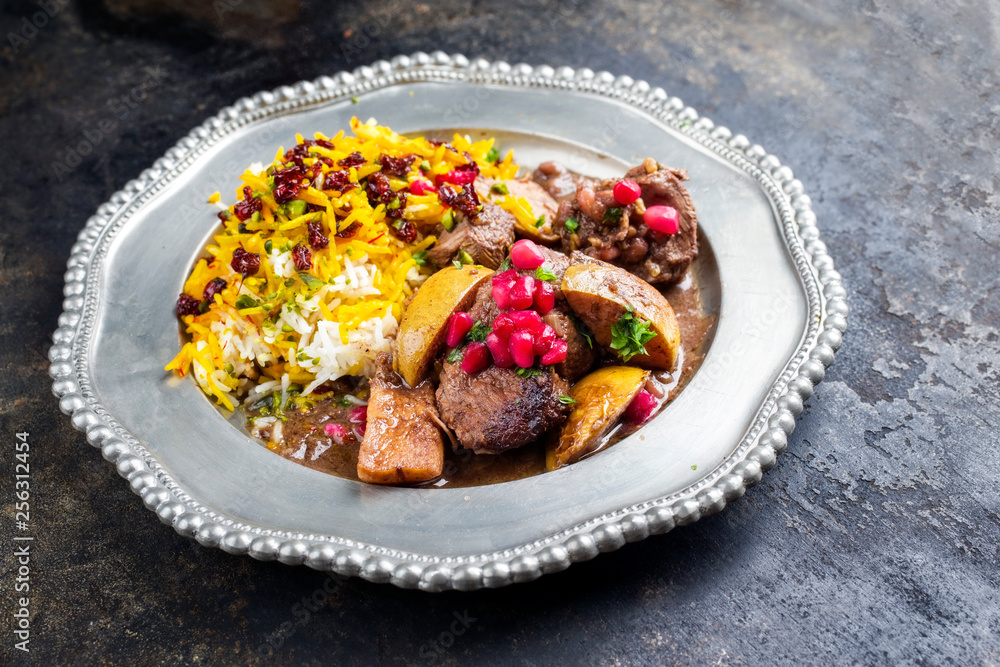 Traditional Iranian khoresh beh stew with chunks of lamb, quinces and saffron rice as a closeup on a pewter plate Traditional Iranian khoresh beh stew with chunks of lamb, quinces and saffron rice as a closeup on a pewter plate