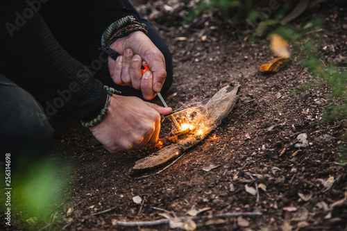 Obraz na plátně Man making fire with tinder polypore fungus in a forest