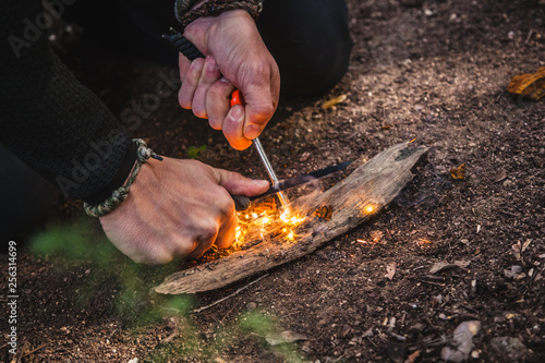 Принти на полотні Man making fire with tinder polypore fungus in a forest