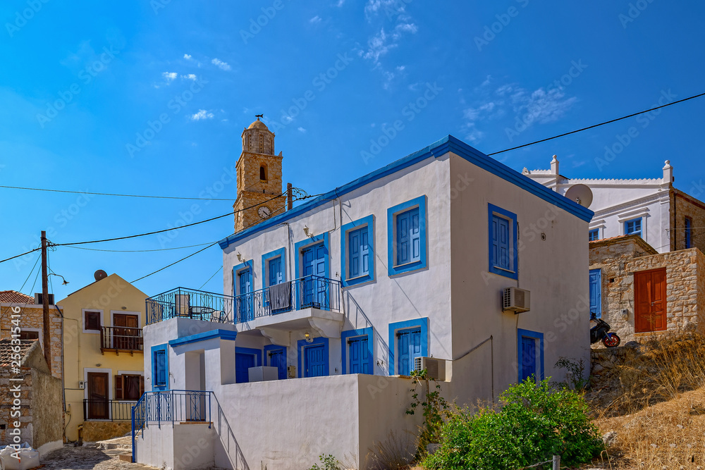 Typical white and blue color Greek house in coastal town on the Greek island of Halki.