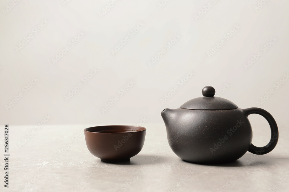 Cup and teapot with oolong on light background. Space for text Cup and teapot with oolong on light background. Space for text