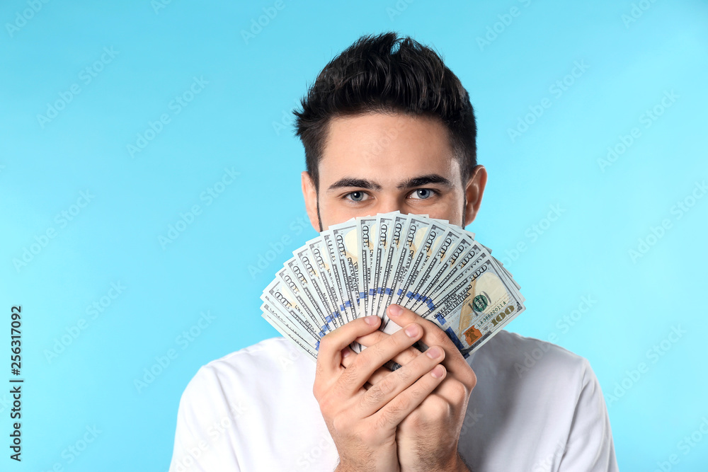 Portrait of happy young man with money on color background Portrait of happy young man with money on color background