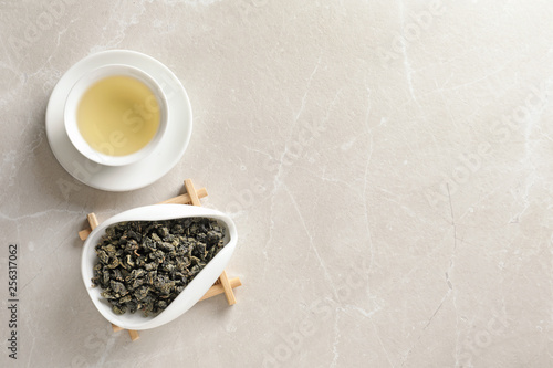 Cup of Tie Guan Yin oolong and chahe with tea leaves on table  top view. Space for text