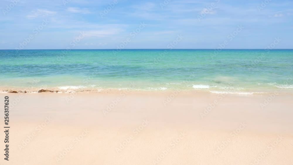 Pastel cloured ocean view with waves gently rippling against the smooth, beige shore Pastel cloured ocean view with waves gently rippling against the smooth, beige shore