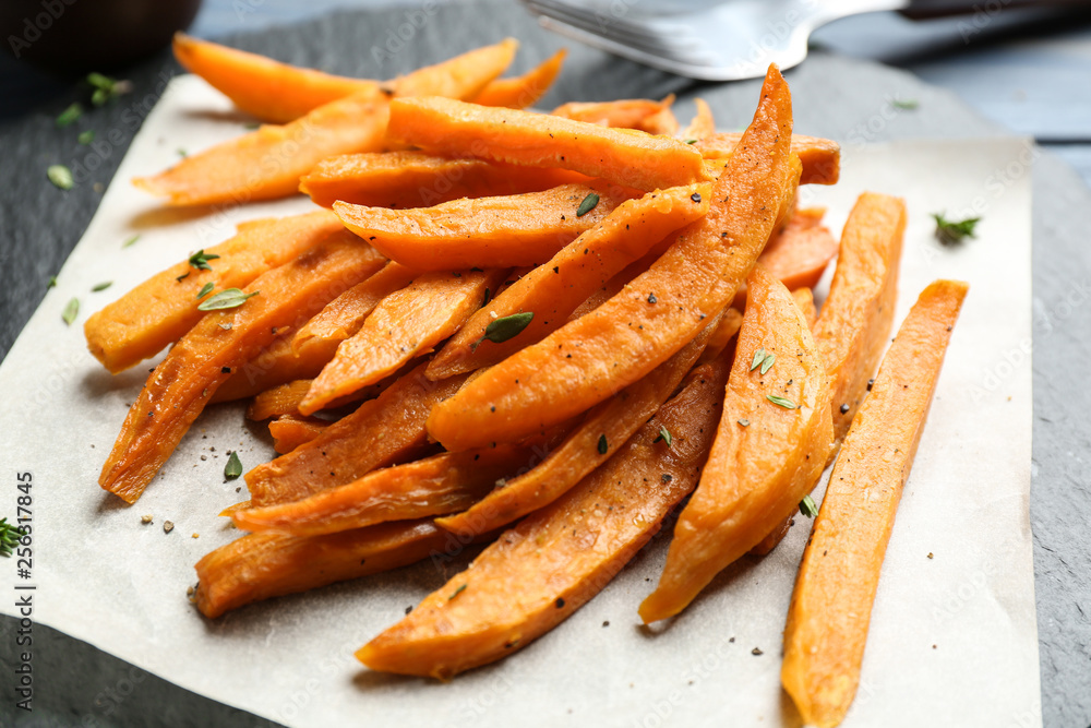 Tasty sweet potato fries on slate plate, closeup