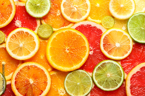 Slices of fresh citrus fruits as background, top view
