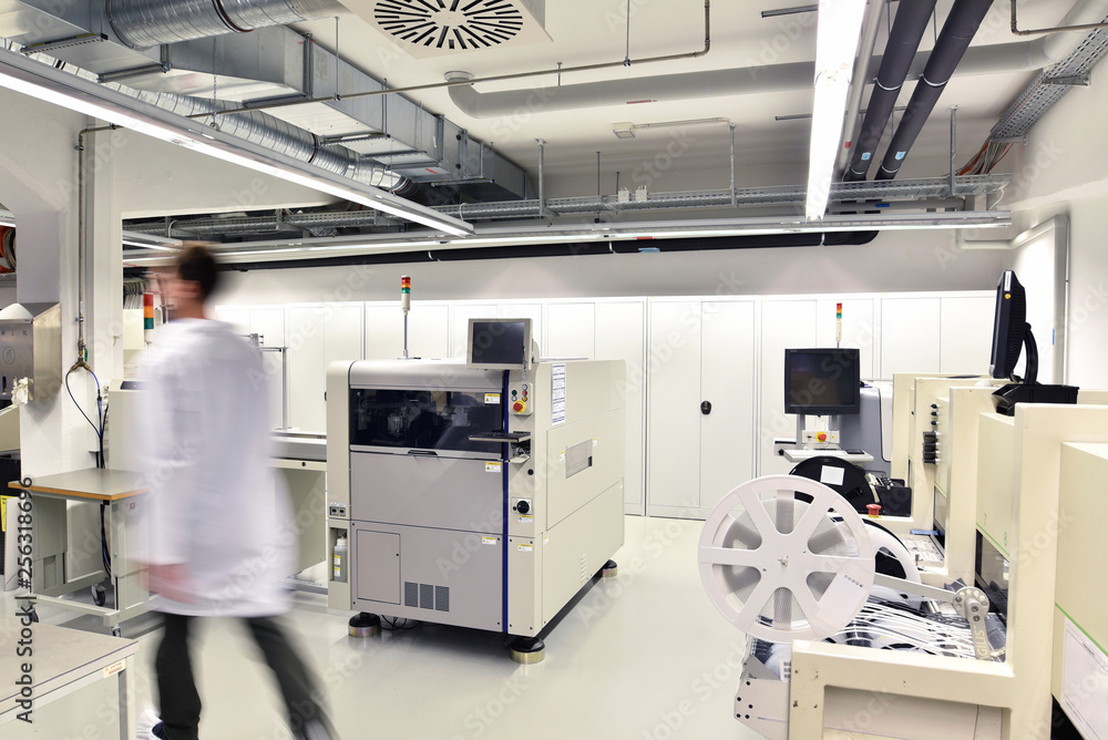 Man walking in a factory for manufacturing of circuit boards for the electronics industry