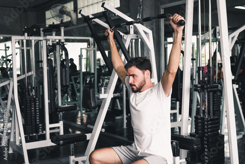 Handsome Man is Rowing Exercise With Bodybuilder Equipment in Fitness Club.,Portrait of Strong Man doing Working Out Calories Burning in Gym., Healthy and Fitness Sport Gym Concept.