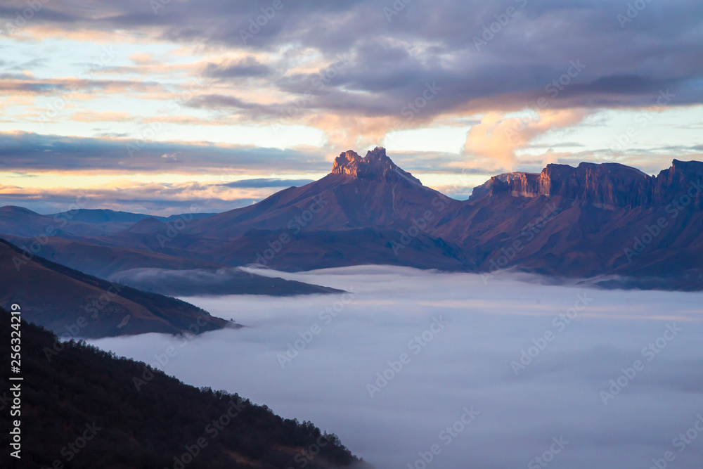 Fog in the mountain gorge, high rocks over clouds. nature of the North Caucasus