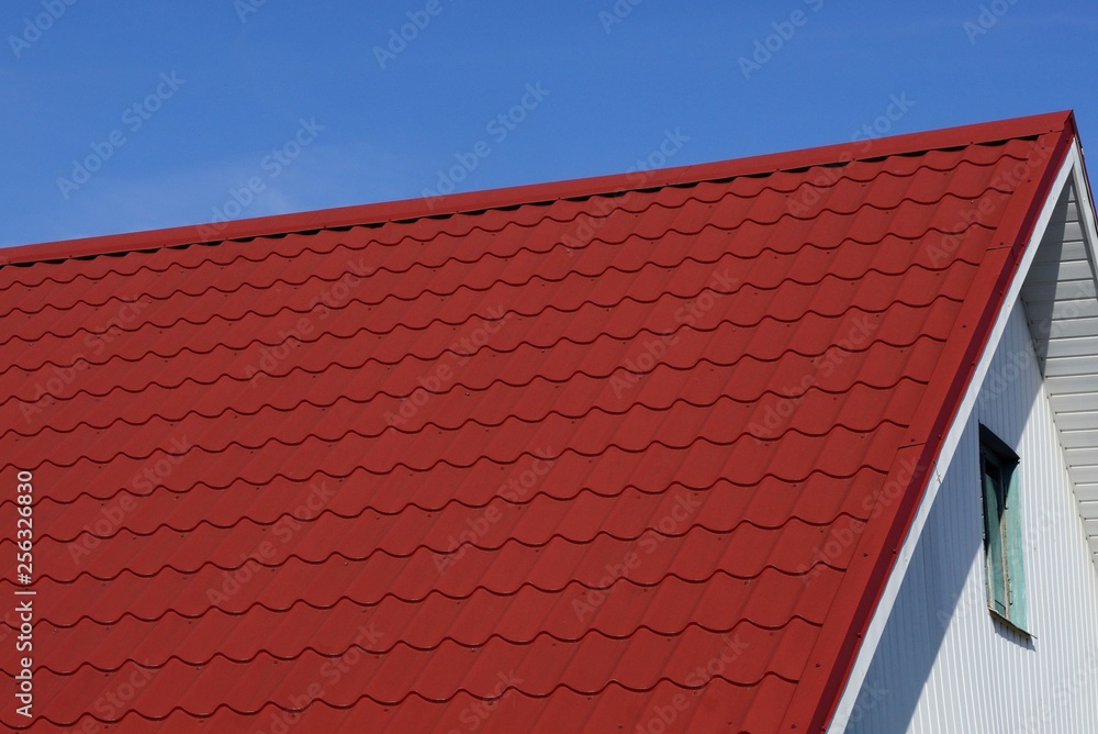 red tiles on the roof of the attic with a window against the blue sky red tiles on the roof of the attic with a window against the blue sky