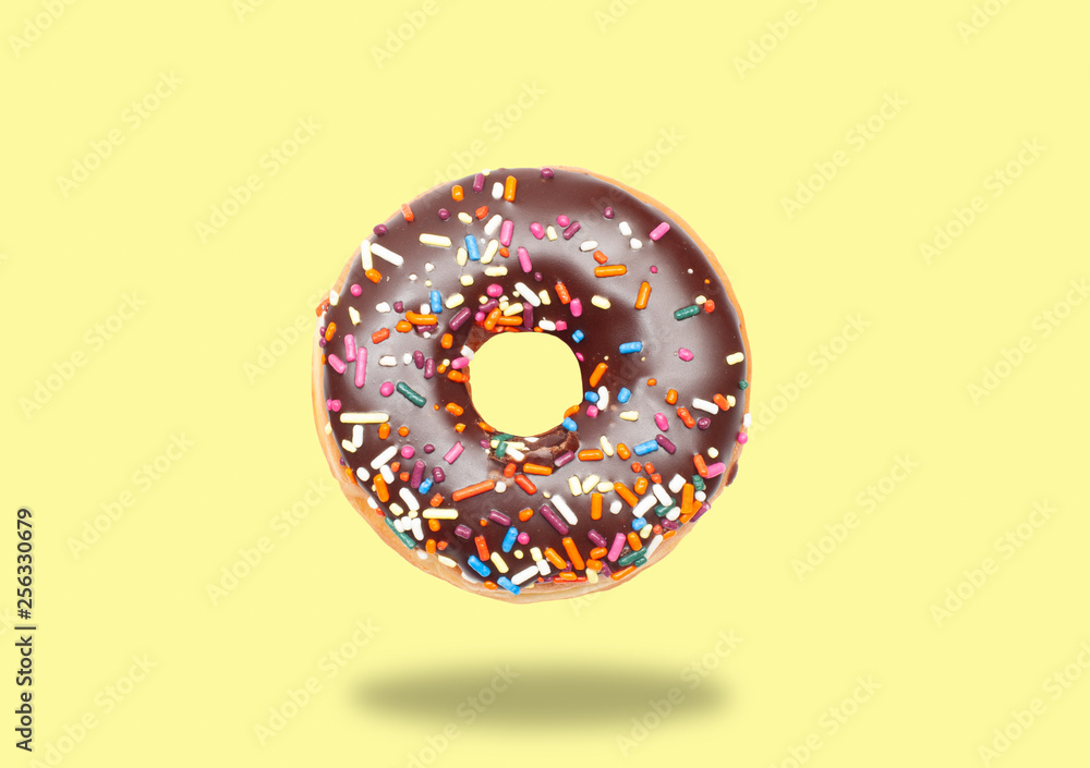 Chocolate donut on pastel yellow background. Chocolate donut on pastel yellow background.