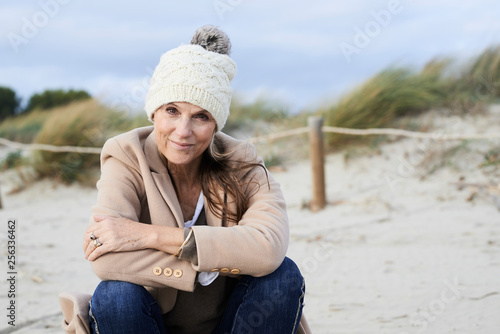 Spain, Menorca, portrait of smiling senior woman wearing bobble hat on the beach in winter © Westend61