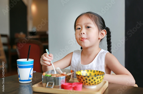 Portrait of little Asian child girl having breakfast at the morning.