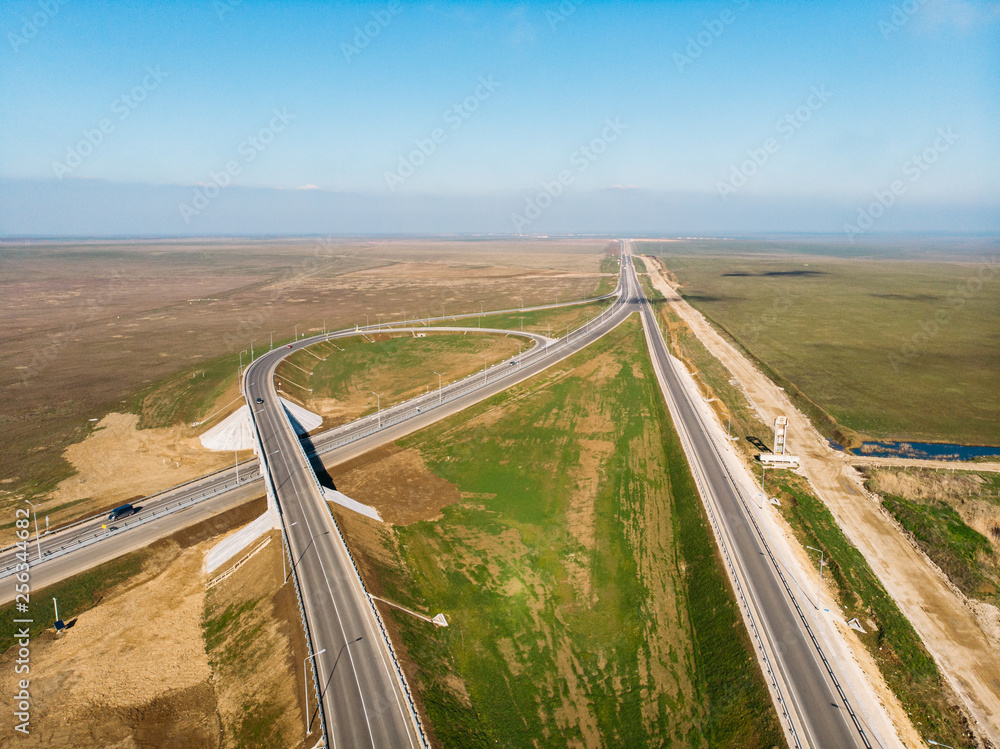 Aerial view of modern new highway road with transportation junction for traffic, drone shot