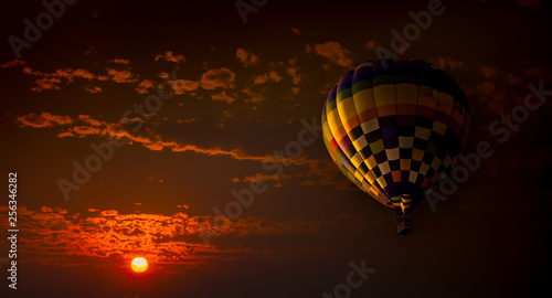 Panorama of hot air balloon during sunset with sun and clouds