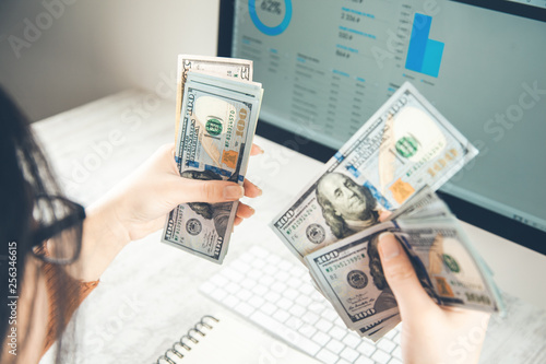 woman hand money with graph on computer screen