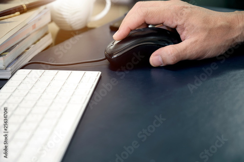 Shot of man hand holding mouse while working at office desk with copy space.
