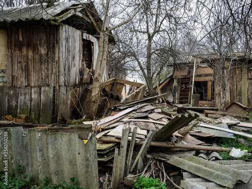 The left houses as a result of disaster. Full ruin of wooden constructions photo