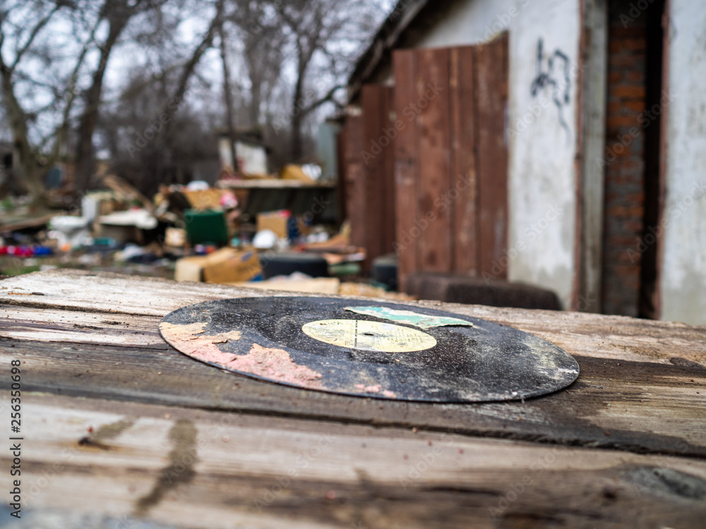 Old musical plate on a dump. A dirty plate among garbage
