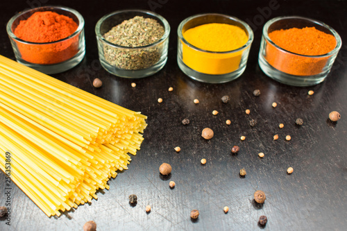 Pasta on black background and spices photo