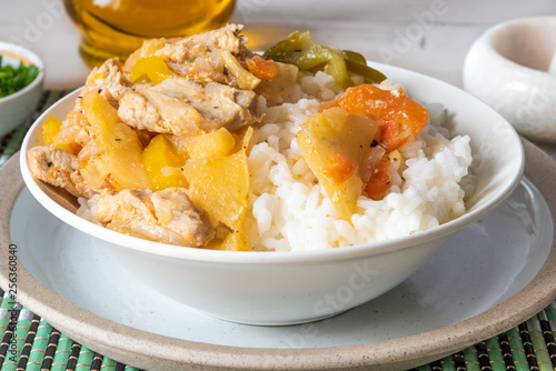 Chicken and apple curry with rice in a bowl on a bamboo napkin - Asian cuisine.