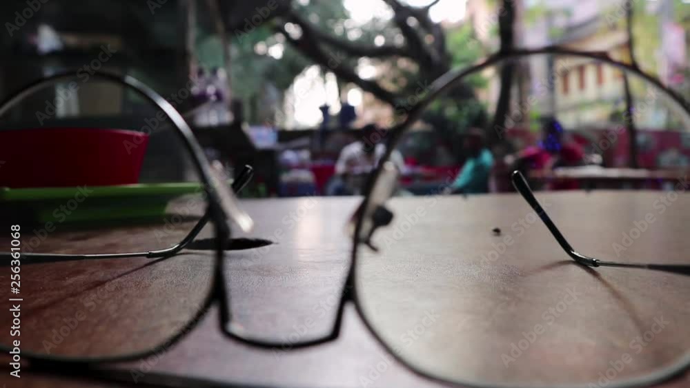 eye glass on coffee table with people on background eye glass on coffee table with people on background