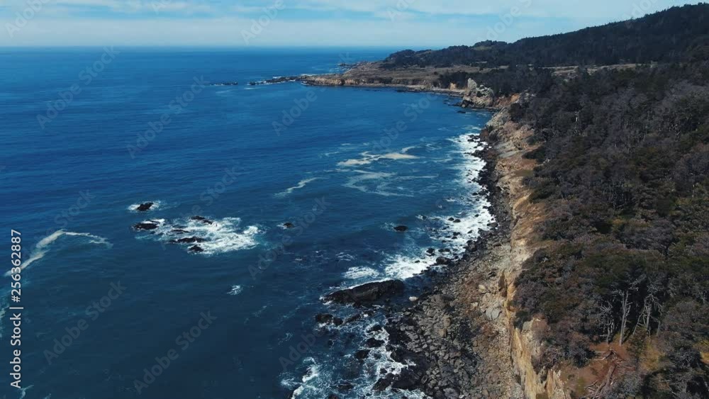 Sun drenched rocks are rhythmically beaten by Pacific Ocean Waves. Cliffs and rugged trees frame the seashore. Drone based aerial video. Cinematic and beautiful. Both calming and energizing. Sun drenched rocks are rhythmically beaten by Pacific Ocean Waves. Cliffs and rugged trees frame the seashore. Drone based aerial video. Cinematic and beautiful. Both calming and energizing.