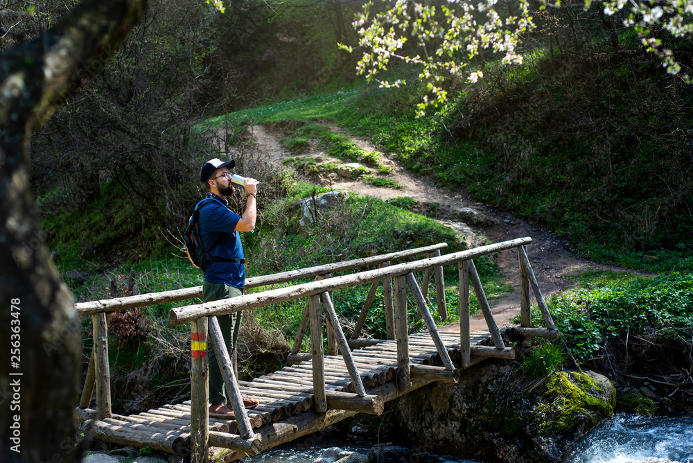 Man drinking water the wooden bridge outdoors Man drinking water the wooden bridge outdoors
