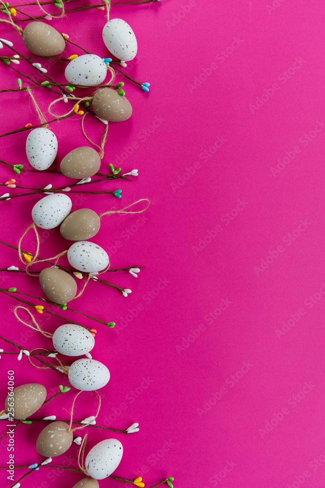 Obraz premium Easter decor. The branches of willow and decorative eggs are laid out on a pink background
