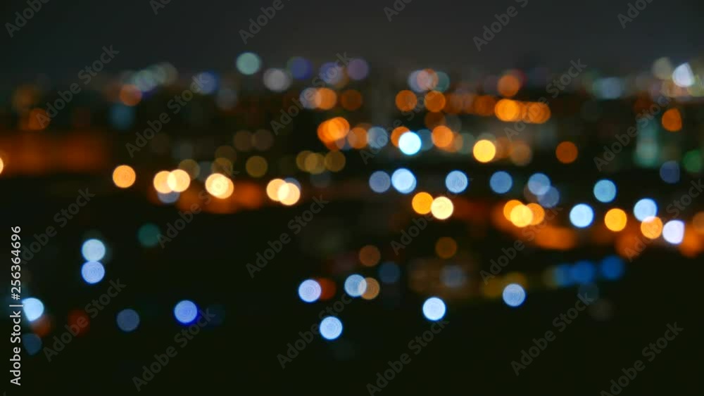 Flickering distant city lights in soft focus create a dreamy abstract bokeh effect