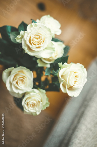 bouquet of pale yellow roses in a vase on the floor