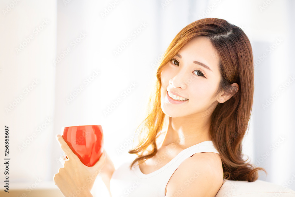 Young beautiful woman drinking coffee on sofa Young beautiful woman drinking coffee on sofa