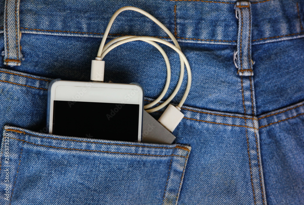 mobile phone with backup mobile battery in jean pocket.mobile phone is tranfer power from backup mobile battery. mobile phone with backup mobile battery in jean pocket.mobile phone is tranfer power from backup mobile battery.
