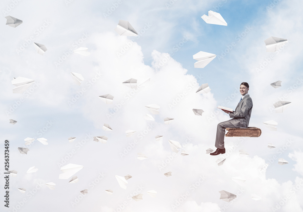 Businessman or student reading book and paper planes flying arou Businessman or student reading book and paper planes flying arou