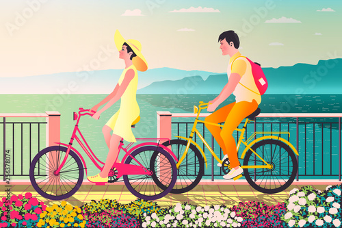A couple of young people on bicycles on vacation at the seaside