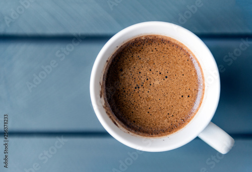 mug of black coffee on a gray wooden background  top view closeup
