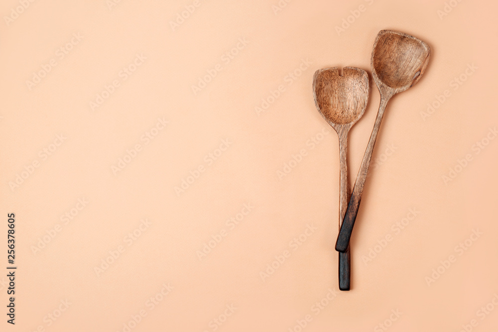 Two wooden Salad Spoons on coral background. Flat lay, top view. Flat lay, top view. Two wooden Salad Spoons on coral background. Flat lay, top view. Flat lay, top view.