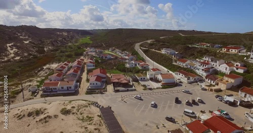 The town of Monte Clerigo with a car driving on the cliffs. Aerial shot.