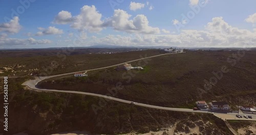 The town of Monte Clerigo with a car driving on the cliffs. Aerial shot.
