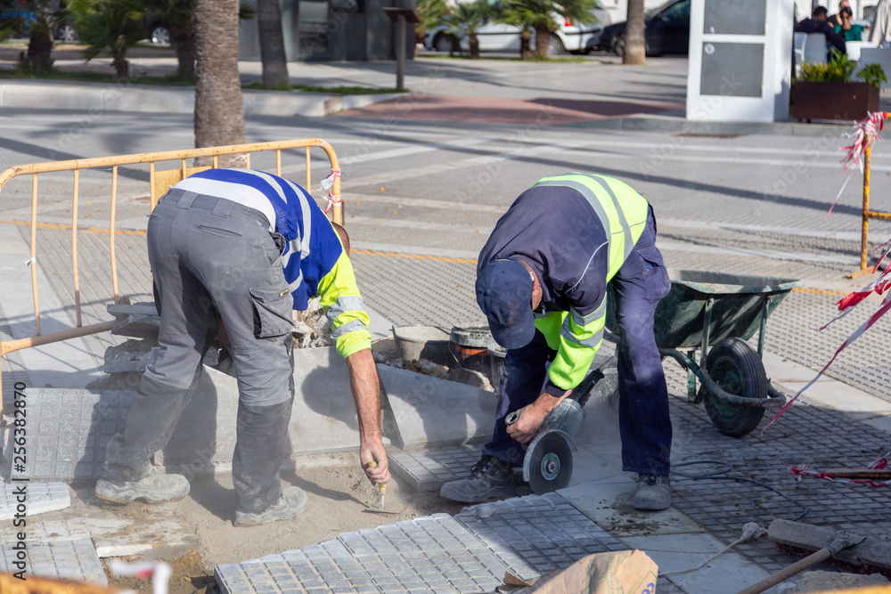 Roadworks. Two men paving brick pathway. Roadworks. Two men paving brick pathway.