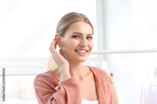 Young woman with hearing aid at home