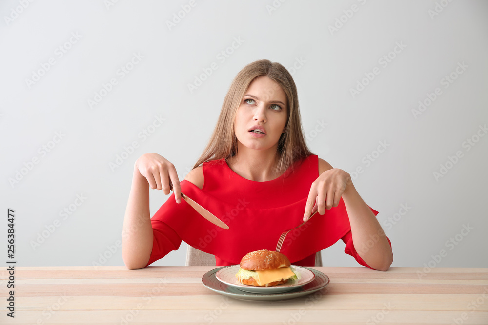 Thoughtful woman with tasty burger at table Thoughtful woman with tasty burger at table