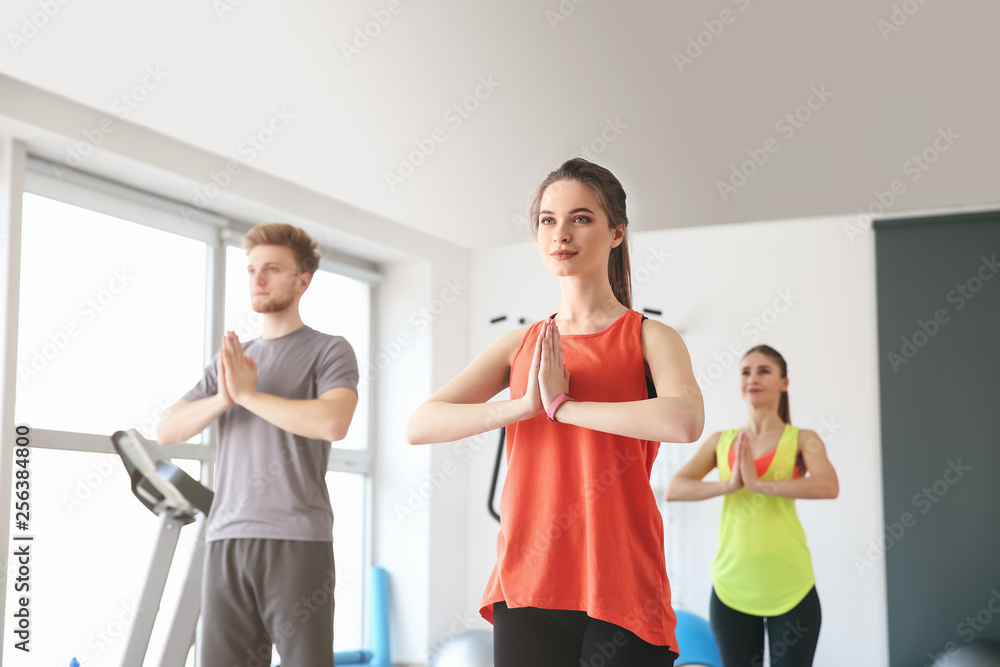 Group of people practicing yoga in gym Group of people practicing yoga in gym