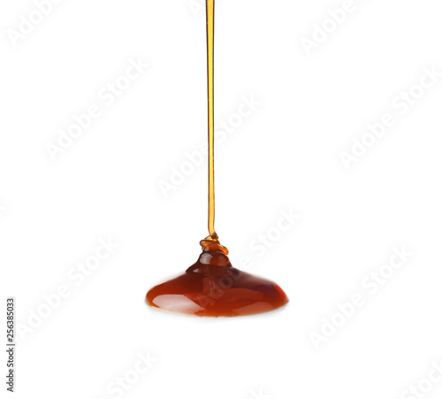 Pouring liquid caramel on white background