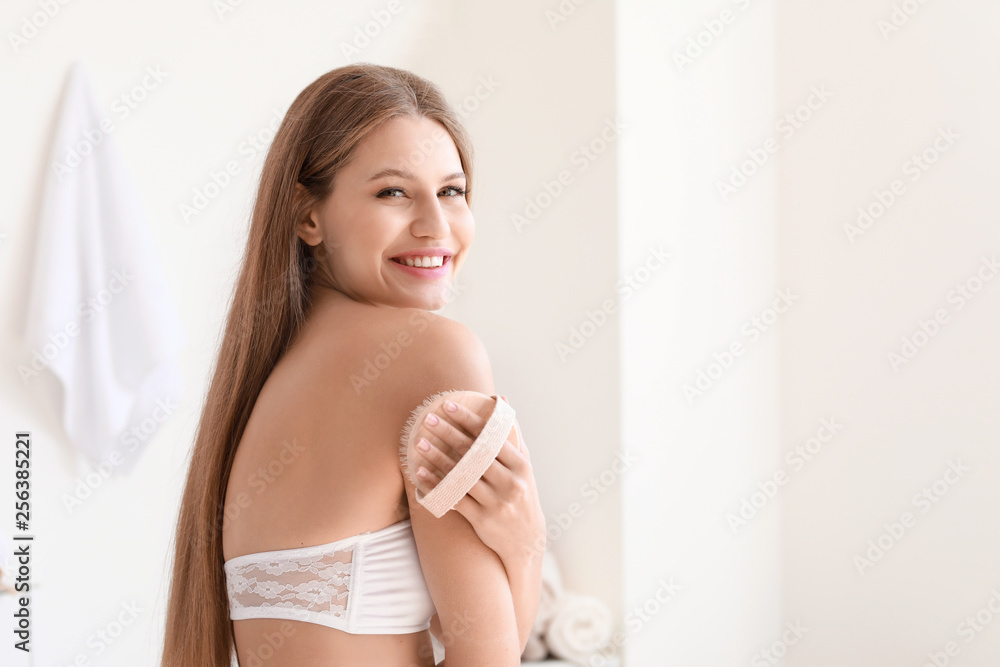 Beautiful young woman with massage brush in bathroom Beautiful young woman with massage brush in bathroom