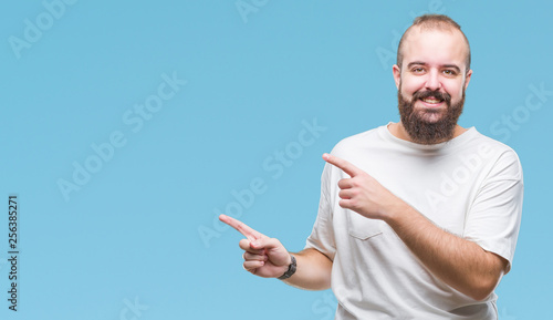 Young caucasian hipster man wearing casual t-shirt over isolated background smiling and looking at the camera pointing with two hands and fingers to the side.