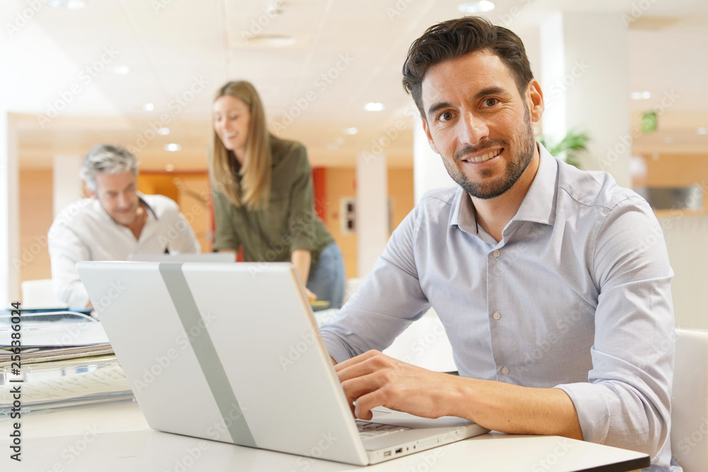 Startup team member working on computer in office Startup team member working on computer in office